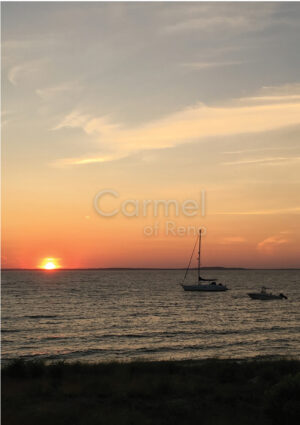 Photograph of the sun setting on the ocean.